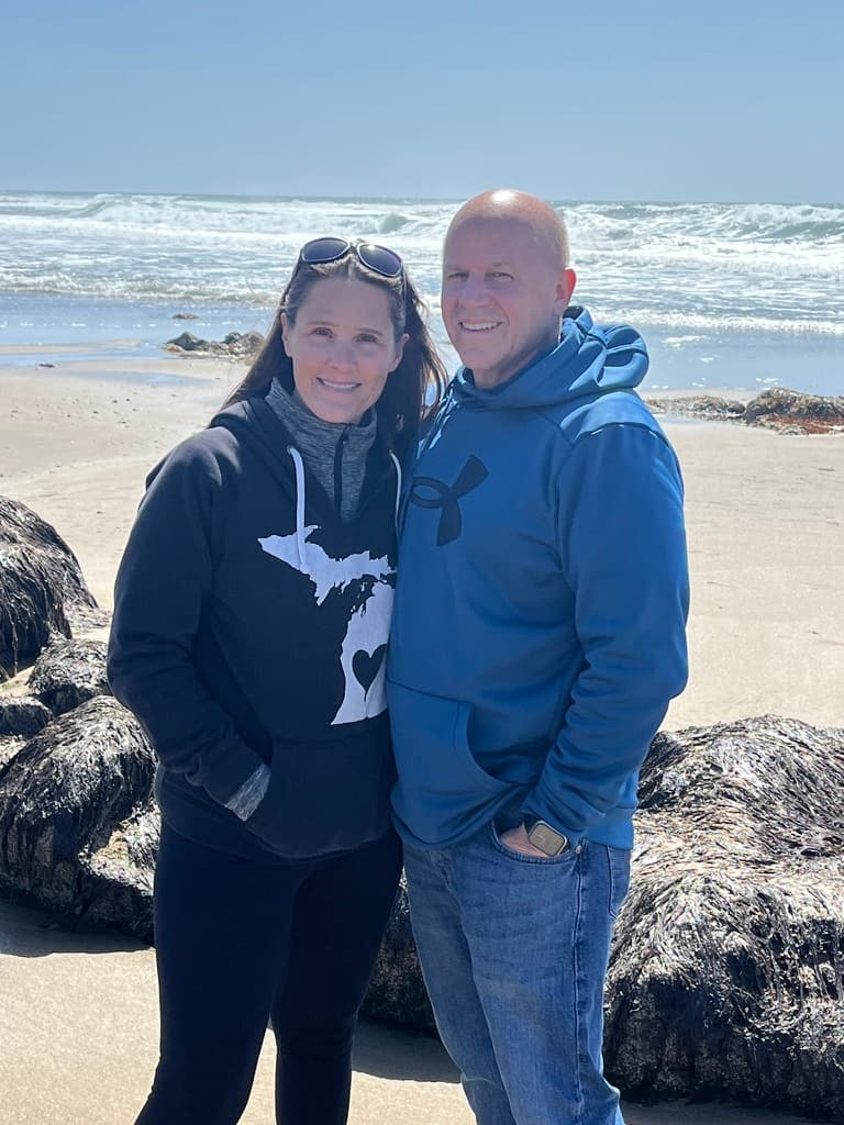 Julie and Shawn Pierson standing together by the water — the founders of The Scratch Club